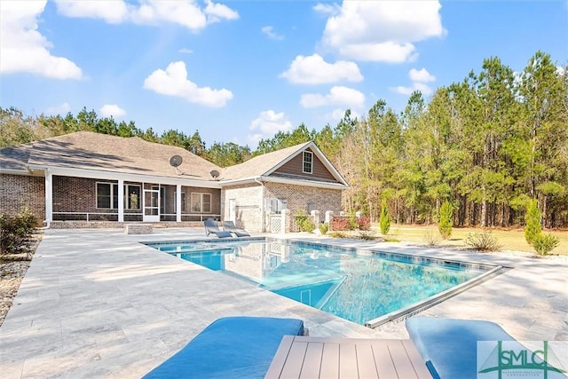 outdoor pool with a patio and a sunroom