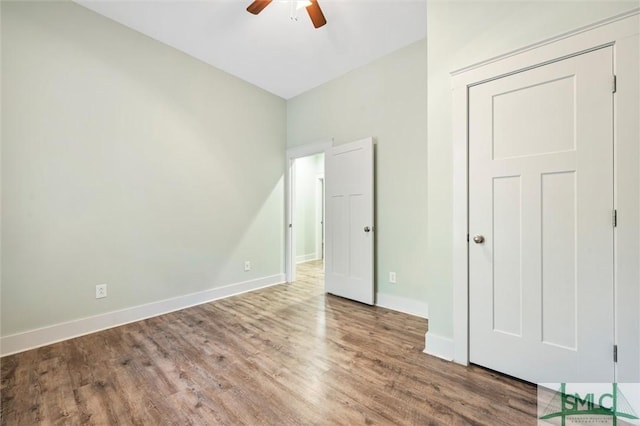 unfurnished bedroom featuring ceiling fan, baseboards, and wood finished floors