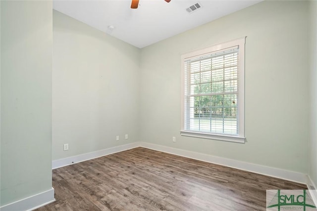 empty room featuring visible vents, baseboards, ceiling fan, and wood finished floors