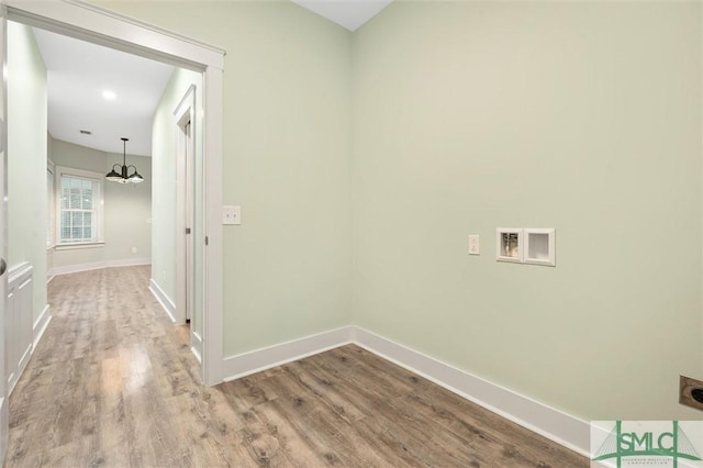 clothes washing area with hookup for a washing machine, wood finished floors, baseboards, hookup for an electric dryer, and a chandelier