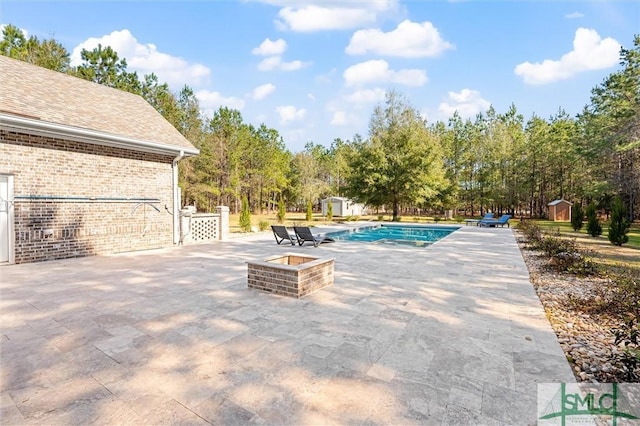 outdoor pool featuring a patio area, a storage shed, and an outdoor structure