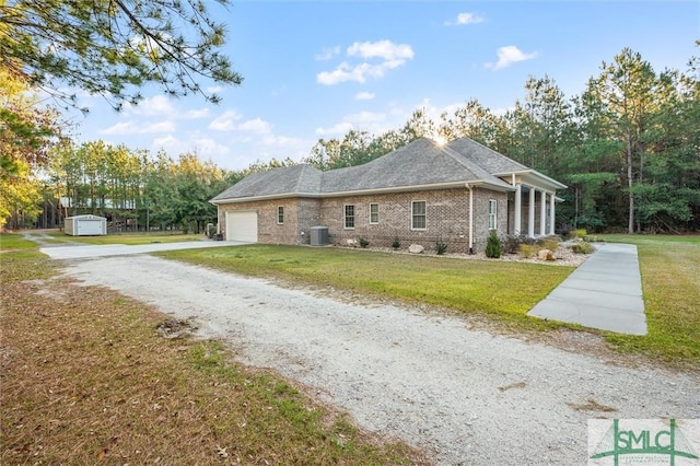 view of side of property with a lawn, a garage, and driveway