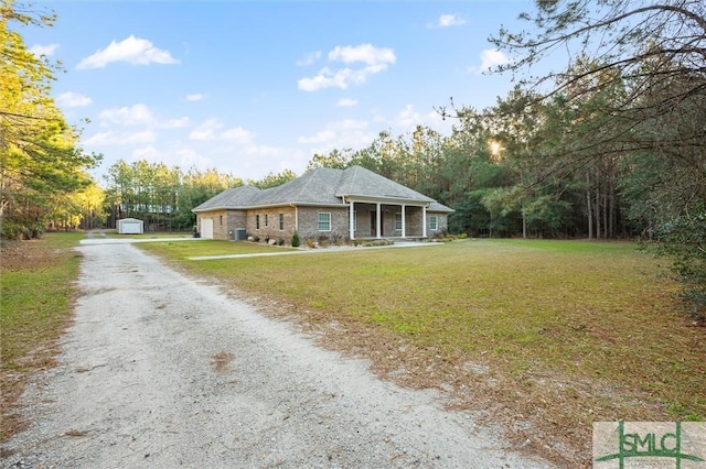 view of front of house with a front lawn, dirt driveway, and an attached garage