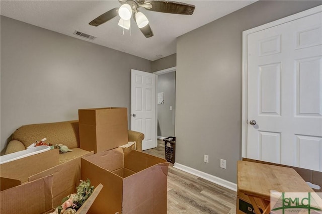 interior space with visible vents, ceiling fan, baseboards, and wood finished floors