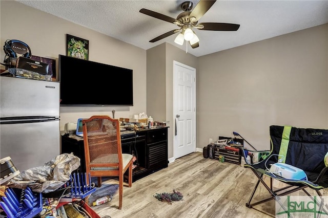 office with ceiling fan, a textured ceiling, and light wood-style flooring