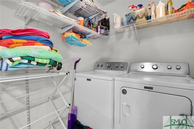 clothes washing area featuring washer and clothes dryer and laundry area