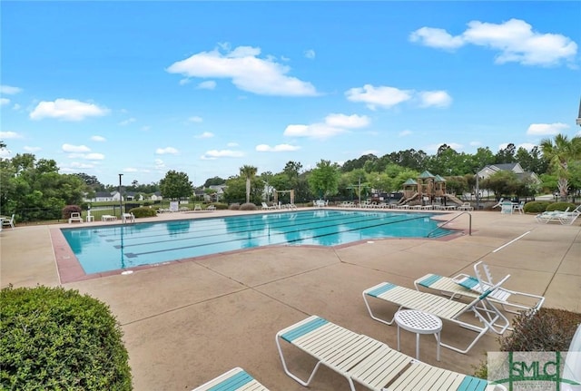 community pool featuring playground community and a patio