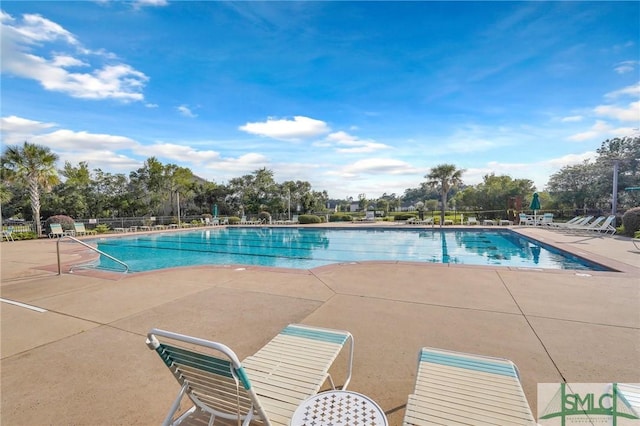 community pool featuring a patio and fence