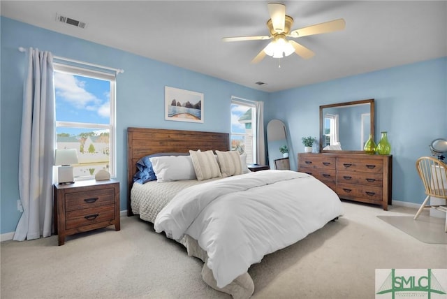 bedroom featuring multiple windows, visible vents, and light carpet