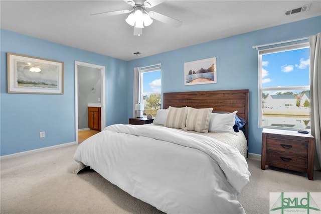 bedroom with visible vents, baseboards, and light carpet