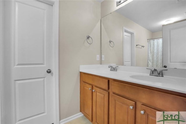 full bathroom featuring double vanity, tile patterned flooring, and a sink