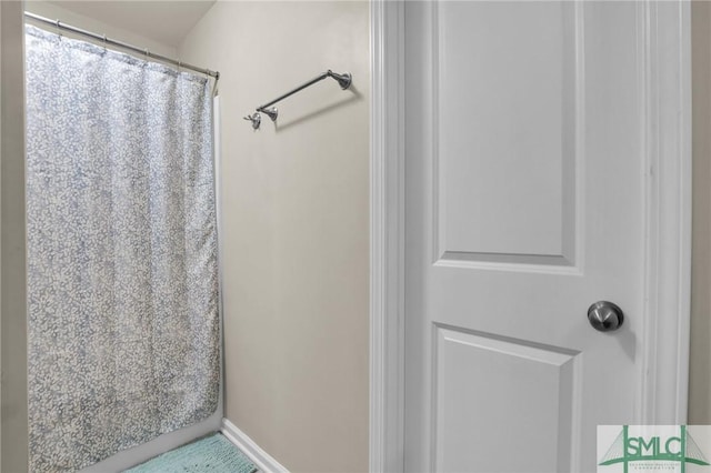 full bath with a shower with curtain and baseboards