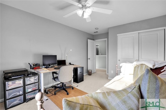 home office with visible vents, baseboards, light colored carpet, and a ceiling fan