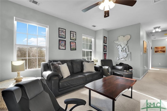 living area featuring visible vents, plenty of natural light, a ceiling fan, and carpet flooring