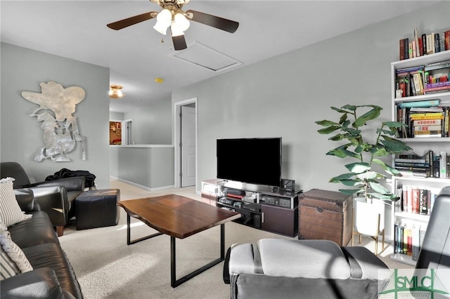 carpeted living area featuring attic access and a ceiling fan