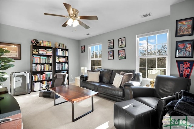 living room featuring visible vents, plenty of natural light, ceiling fan, and carpet flooring