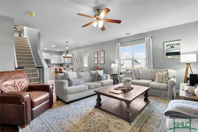 living room with recessed lighting, visible vents, ceiling fan with notable chandelier, and stairs