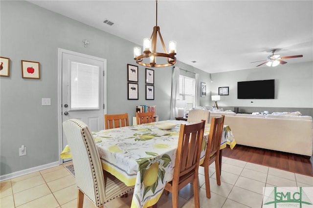 dining area with light tile patterned floors, ceiling fan with notable chandelier, and visible vents