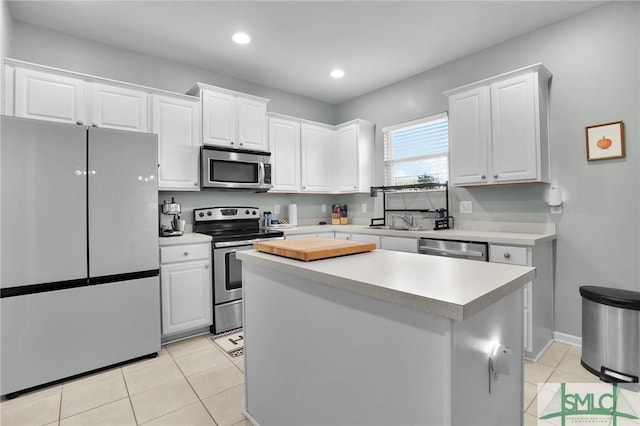 kitchen featuring appliances with stainless steel finishes, white cabinets, and light countertops