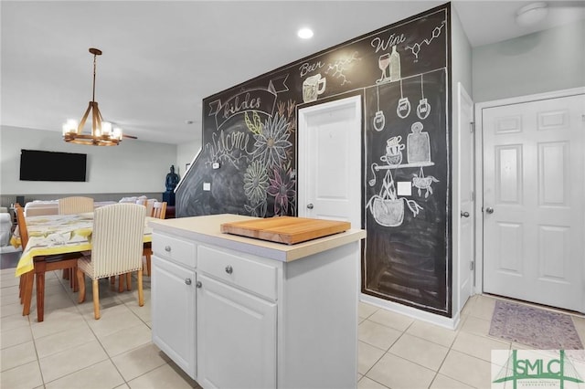 kitchen featuring decorative light fixtures, open floor plan, an inviting chandelier, light tile patterned flooring, and white cabinetry