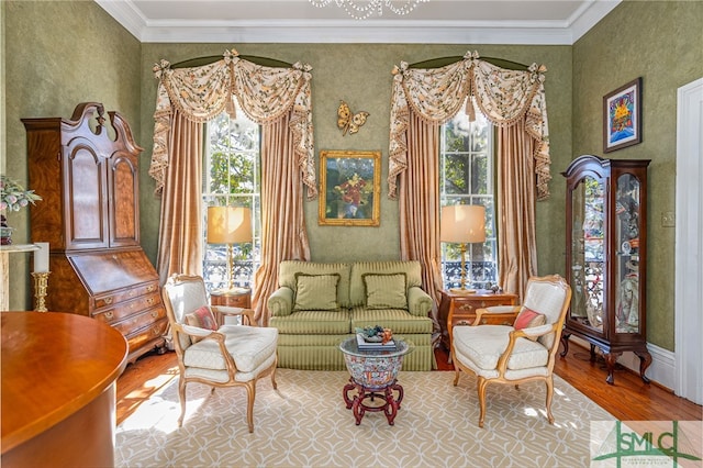 living area with ornamental molding, wood finished floors, and a healthy amount of sunlight