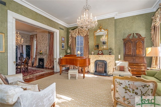 living area with crown molding, a notable chandelier, visible vents, and a high end fireplace