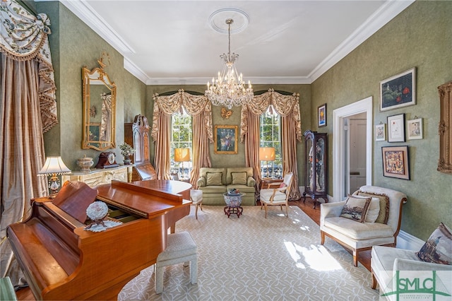 living area with baseboards, wood finished floors, an inviting chandelier, and ornamental molding