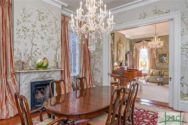 dining space with hardwood / wood-style floors, a high end fireplace, crown molding, wallpapered walls, and a chandelier