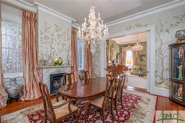 dining room with a chandelier, hardwood / wood-style flooring, wallpapered walls, and ornamental molding