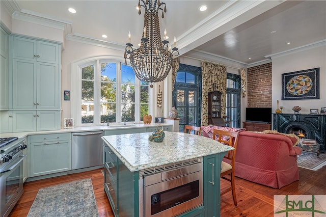 kitchen featuring green cabinetry, wood finished floors, appliances with stainless steel finishes, and a center island