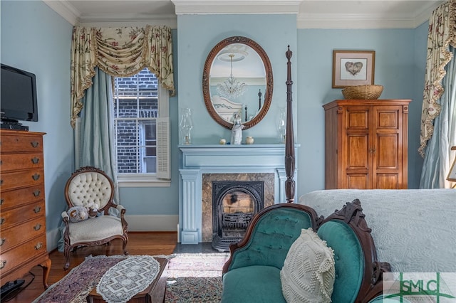 living area featuring a premium fireplace, wood finished floors, baseboards, and ornamental molding