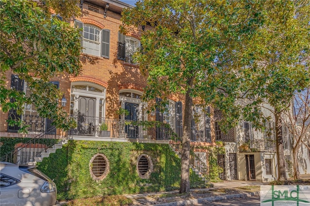 exterior space with brick siding and stairs