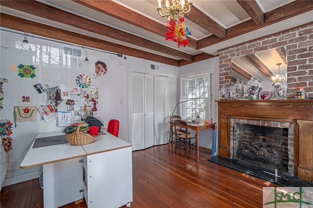 interior space with hardwood / wood-style floors, visible vents, an inviting chandelier, beam ceiling, and a fireplace