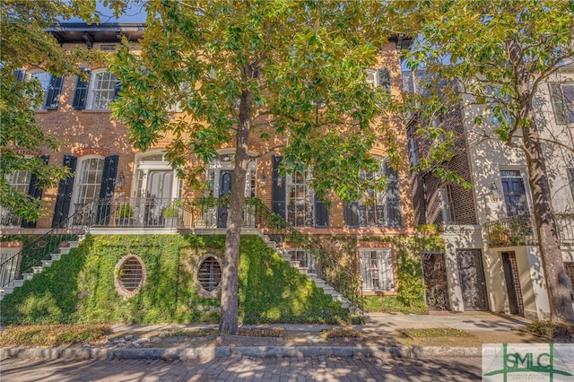 view of front facade featuring brick siding and stairs