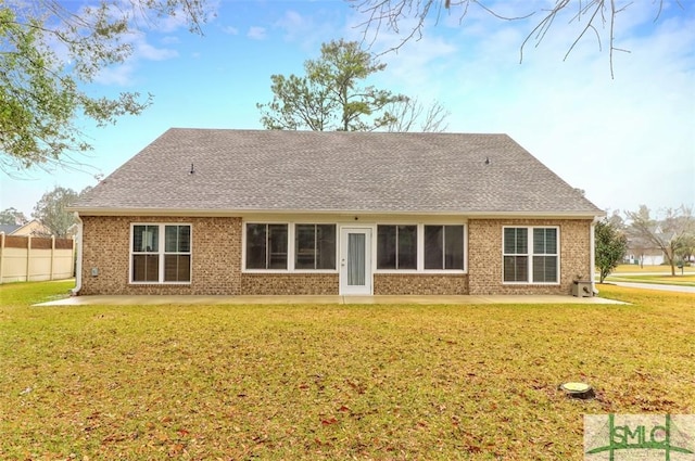 back of house featuring a patio, a lawn, and brick siding