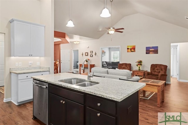 kitchen with a center island with sink, white cabinetry, dark wood finished floors, a sink, and stainless steel dishwasher