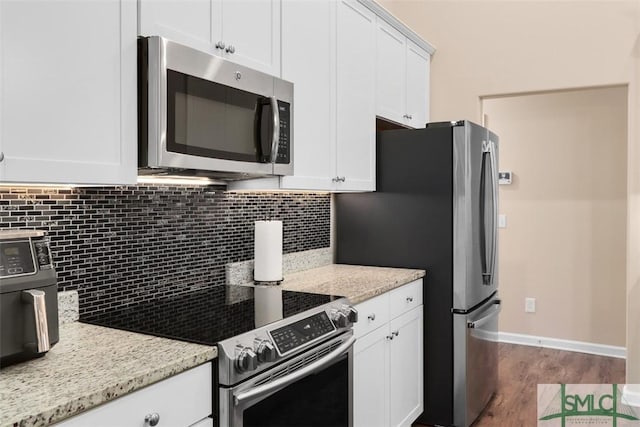 kitchen with dark wood finished floors, decorative backsplash, white cabinetry, and stainless steel appliances