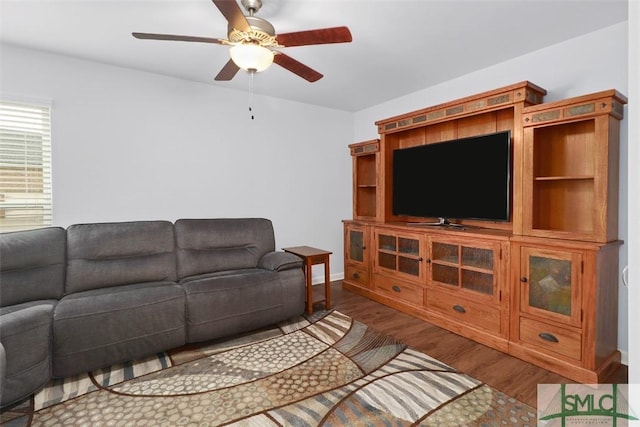 living area with a ceiling fan and wood finished floors