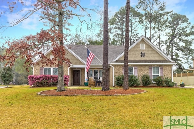 craftsman inspired home with brick siding, a front lawn, and fence