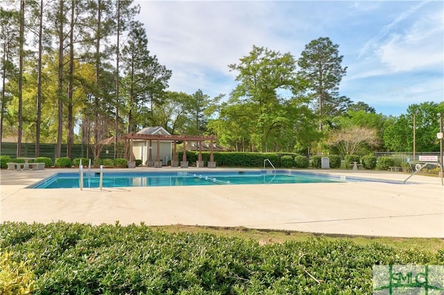 community pool with a patio area and fence