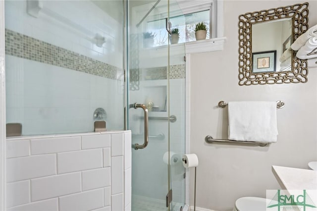 bathroom with vanity, toilet, and a shower stall