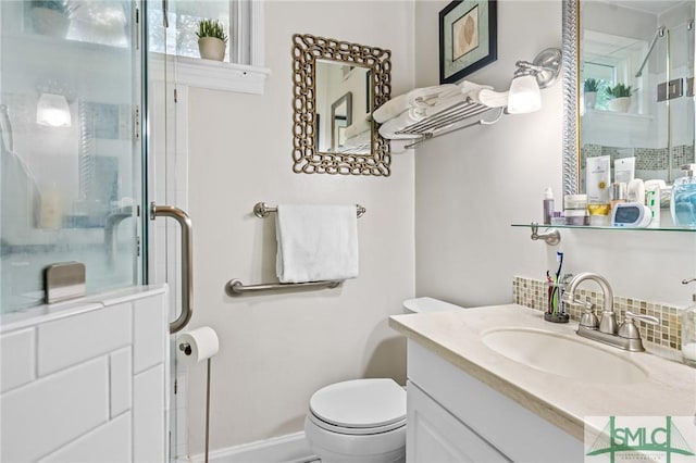 bathroom featuring an enclosed shower, toilet, vanity, and baseboards