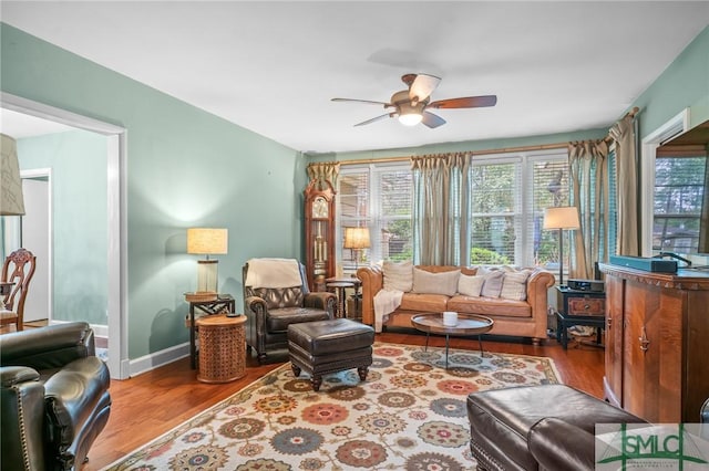 living area with ceiling fan, baseboards, and wood finished floors