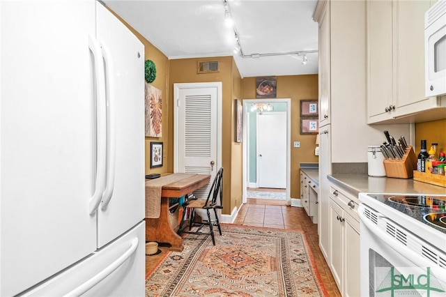 kitchen featuring visible vents, white appliances, light tile patterned flooring, and track lighting