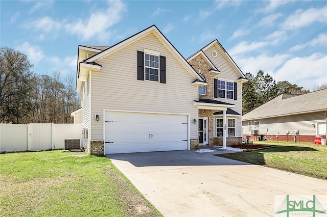 traditional home with stone siding, driveway, a front lawn, and fence