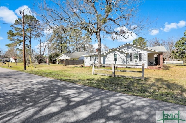 view of side of home featuring a lawn and a fenced front yard