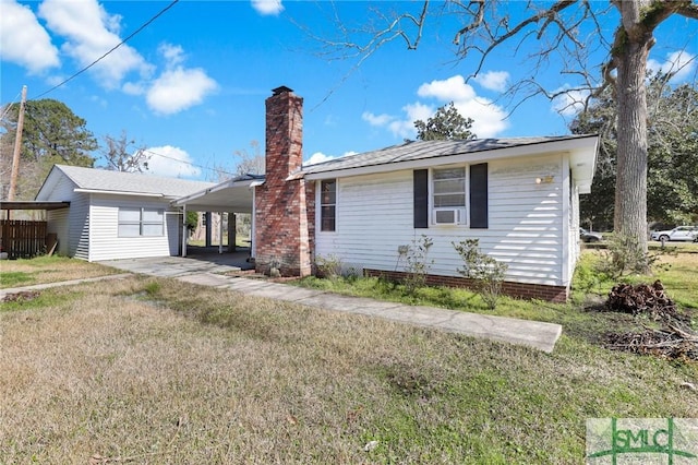 view of front of property featuring a carport, a front yard, driveway, and a chimney