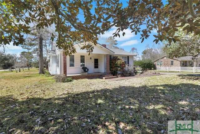 bungalow with a chimney, a porch, a front lawn, and fence