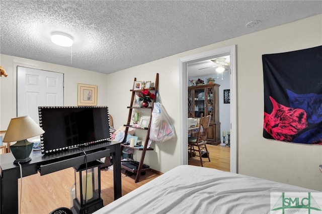 bedroom with a textured ceiling and wood finished floors