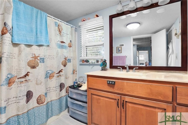 bathroom featuring visible vents, a textured ceiling, and vanity